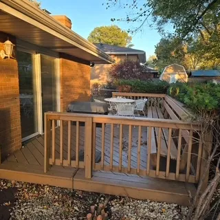 a view of a brick house with a floor to ceiling window and wooden fence