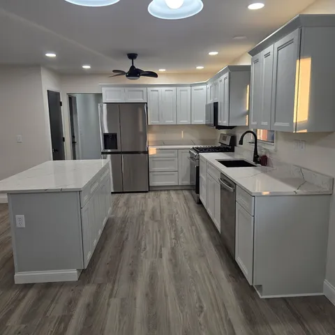 a kitchen with a sink a counter top space stainless steel appliances and cabinets
