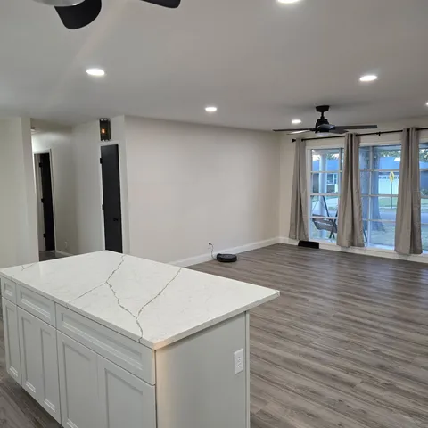 a large kitchen with stainless steel appliances a large counter top a stove a refrigerator and a sink