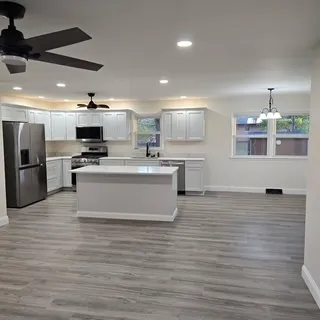 a view of an empty room with wooden floor and a large window