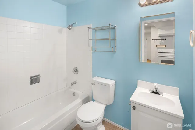 a white toilet sitting next to a bathroom sink and vanity