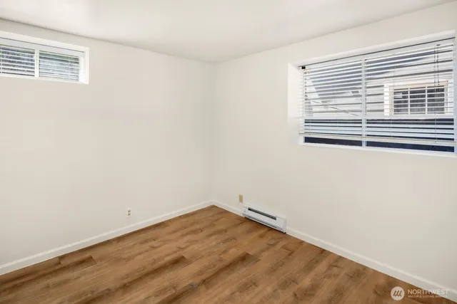 a view of a room with wooden floor and a window