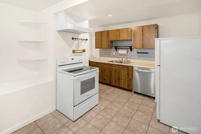 a kitchen with stainless steel appliances granite countertop a stove a sink and a refrigerator