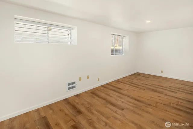 a view of empty room with wooden floor