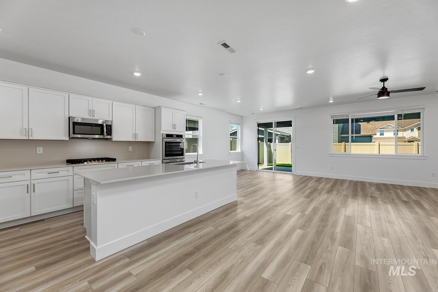 4548 West Wapoot Street Meridian, ID 83646 - Photo 7 of 17 Open-concept living area featuring light wood-finish flooring, recessed lighting, and a modern ceiling fan