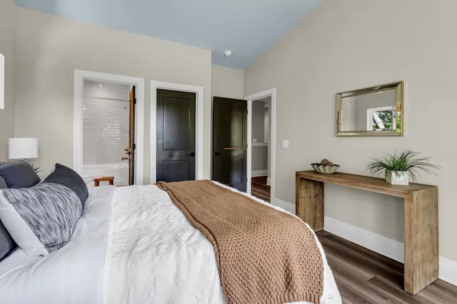 a bedroom with a bed and a potted plant