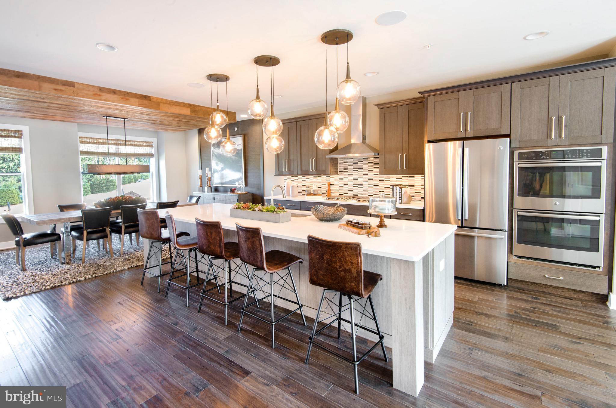 a kitchen with stainless steel appliances a dining table chairs stove and a refrigerator