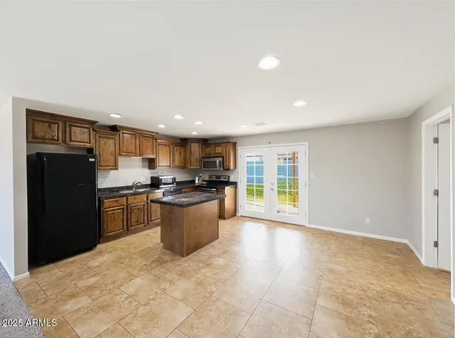 a kitchen with a refrigerator and a stove top oven