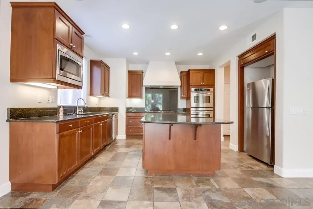 11674 Creek Road Poway, CA 92064 - Photo 20 of 70 a large kitchen with stainless steel appliances granite countertop a refrigerator and a stove top oven