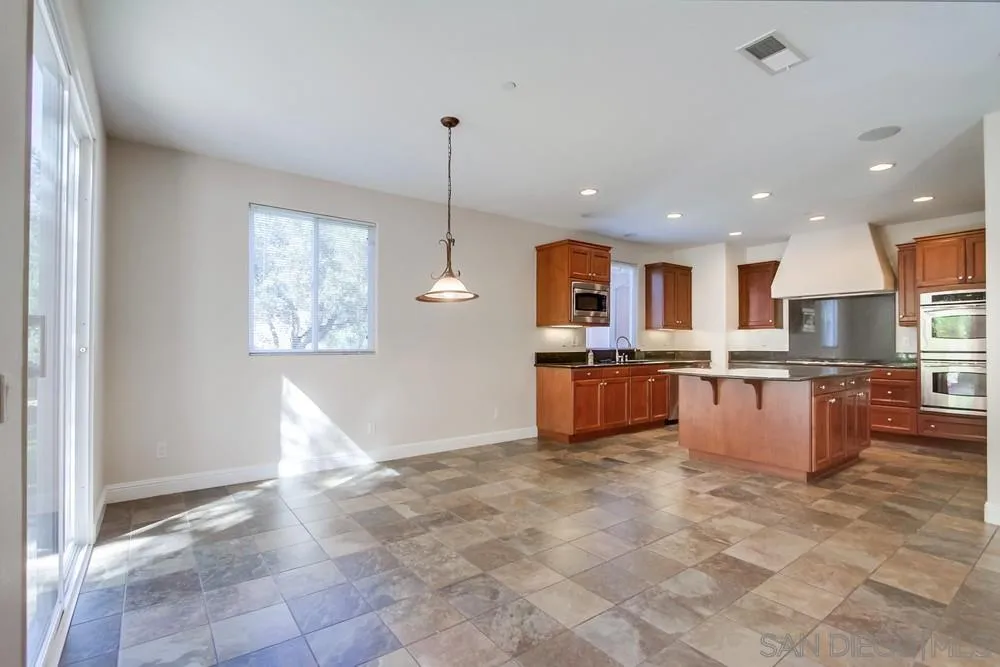 11674 Creek Road Poway, CA 92064 - Photo 21 of 70 a large kitchen with stainless steel appliances kitchen island granite countertop a refrigerator a stove a oven and a sink with granite countertops