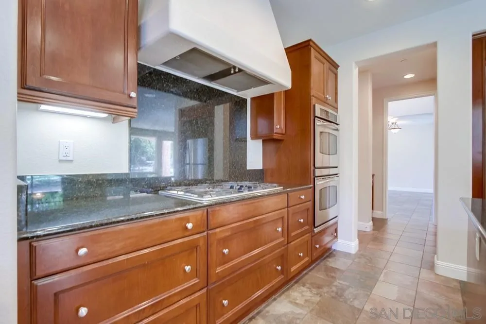 11674 Creek Road Poway, CA 92064 - Photo 23 of 70 a kitchen with granite countertop a sink and cabinets