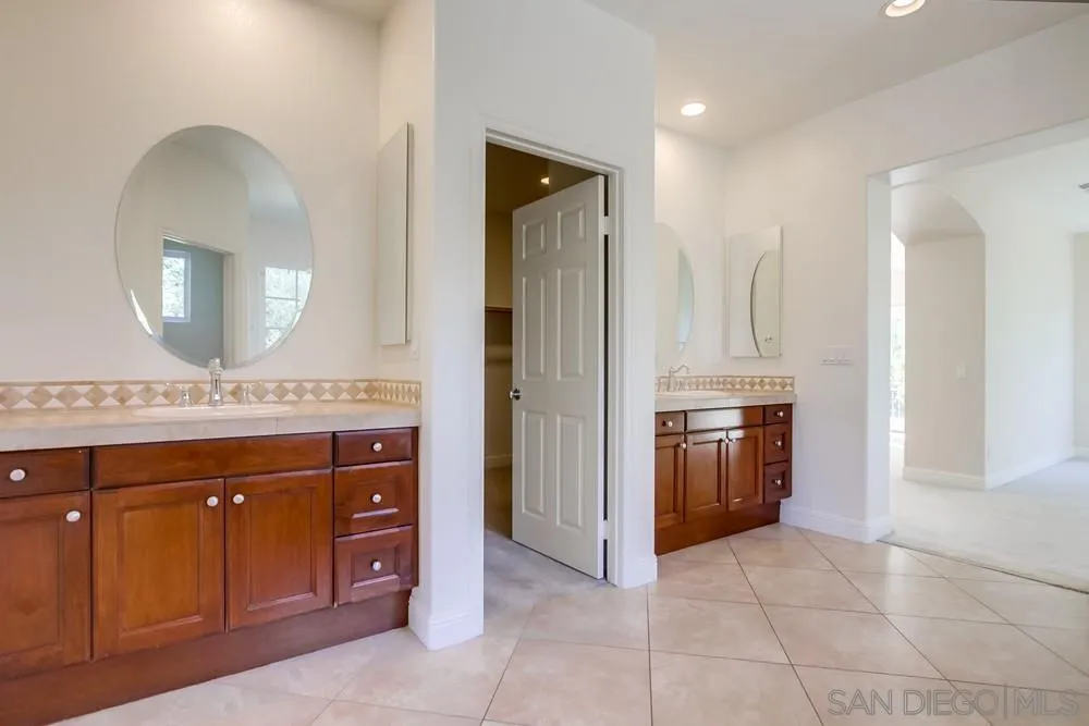 11674 Creek Road Poway, CA 92064 - Photo 25 of 70 a spacious bathroom with a double vanity sink and a mirror