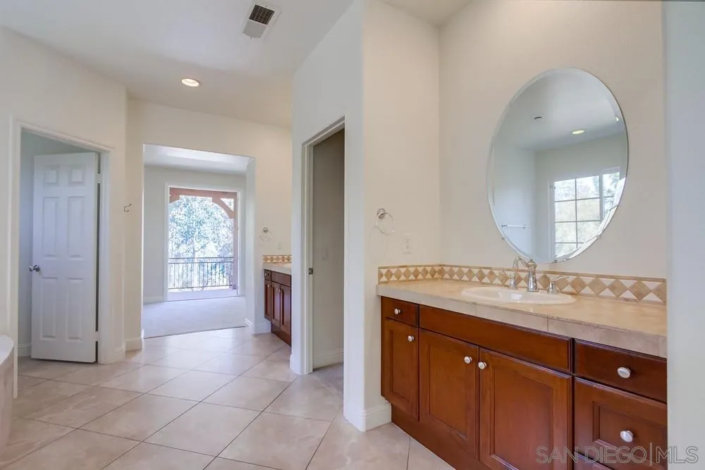 11674 Creek Road Poway, CA 92064 - Photo 29 of 70 a bathroom with a sink vanity and a mirror
