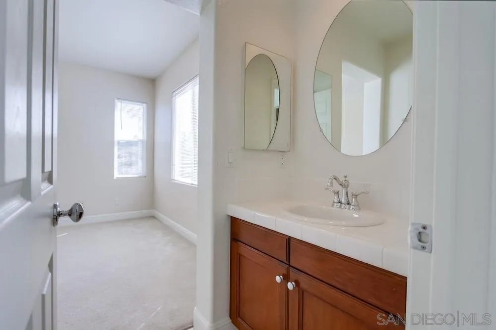 11674 Creek Road Poway, CA 92064 - Photo 40 of 70 a bathroom with a double vanity sink and mirror
