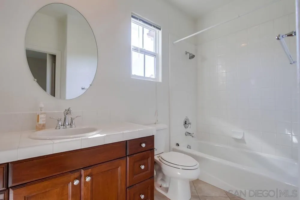 11674 Creek Road Poway, CA 92064 - Photo 46 of 70 a bathroom with a toilet a sink a mirror and a bathtub