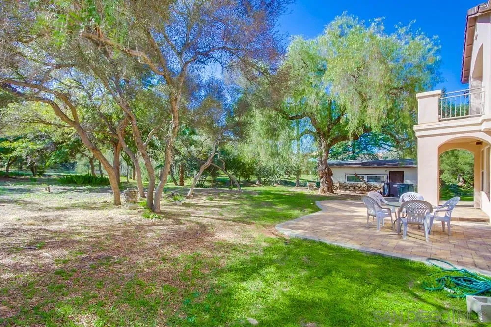 11674 Creek Road Poway, CA 92064 - Photo 53 of 70 a view of a backyard with table and chairs and a large tree