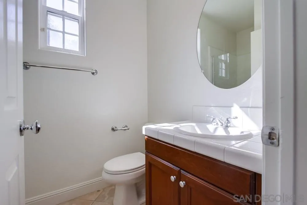11674 Creek Road Poway, CA 92064 - Photo 66 of 70 a bathroom with a granite countertop toilet sink and mirror