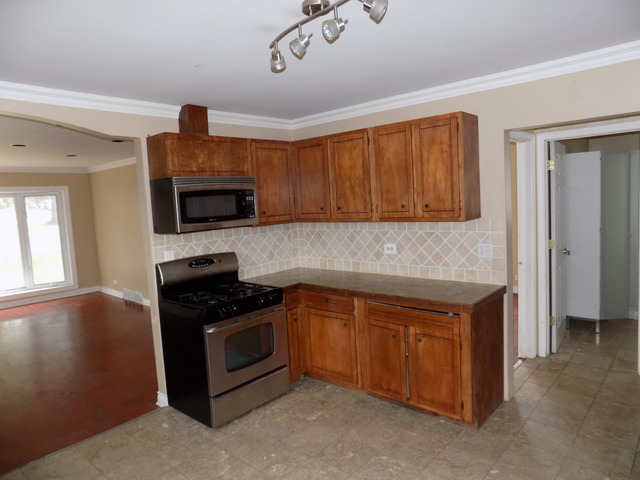 3N270 Rohlwing Road Addison, IL 60101 - Photo 3 of 13 a kitchen with stainless steel appliances granite countertop a stove a sink and a microwave