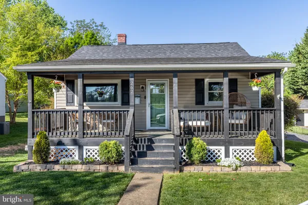 a view of a house with wooden deck and a bench