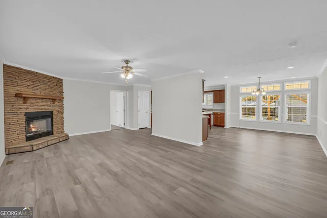 a view of an empty room with a window and fireplace