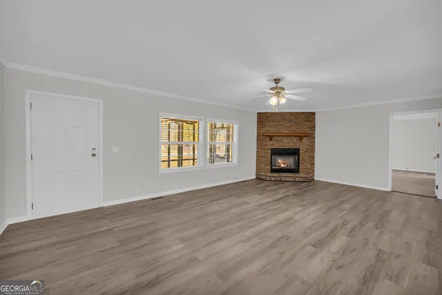 a view of an empty room with a fireplace and a window