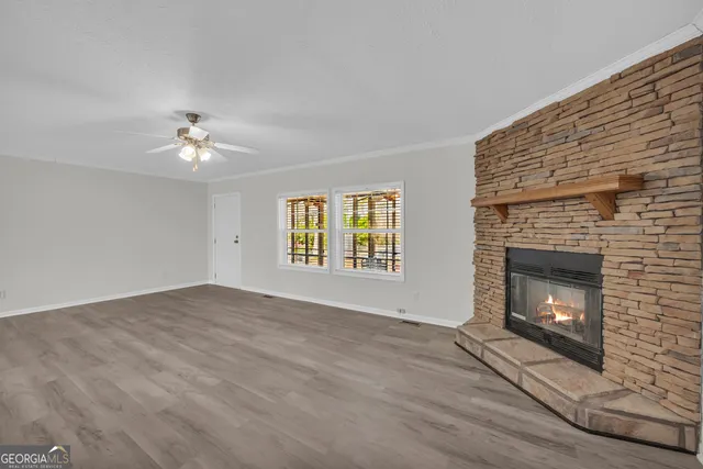 a view of an empty room with a fireplace and a window