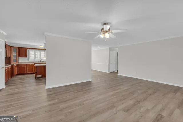 a view of an empty room with a window and wooden floor