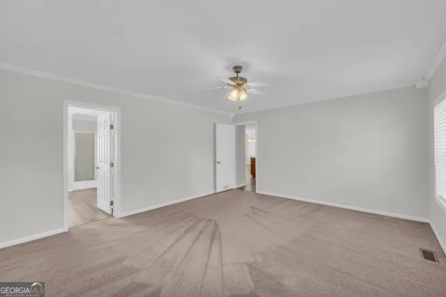 a view of an empty room with a chandelier fan