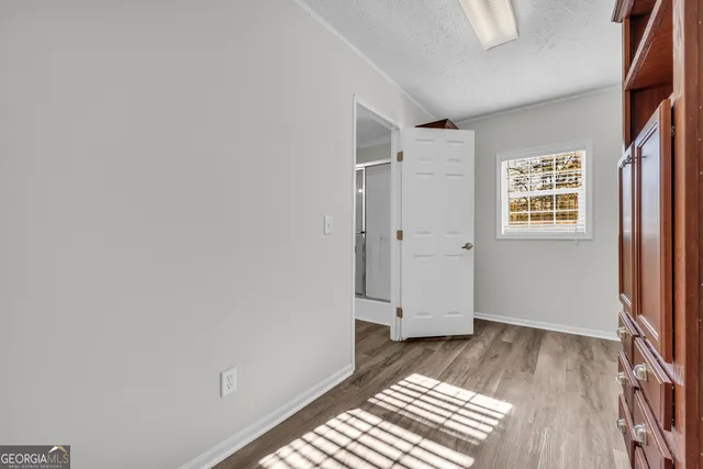 an empty room with wooden floor and window