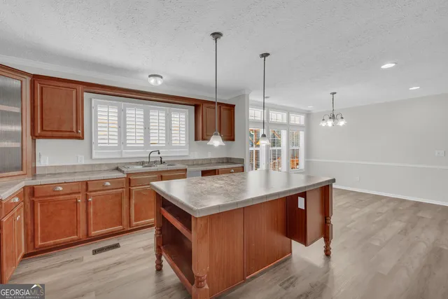 a kitchen with stainless steel appliances granite countertop a sink a window and wooden floor
