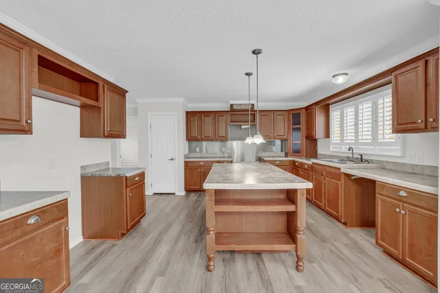 a kitchen with a stove a sink and wooden floor