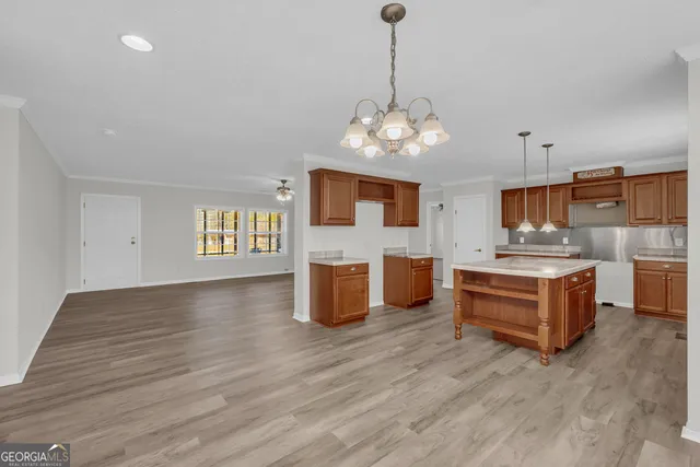 a large kitchen with stainless steel appliances granite countertop a stove oven and a wooden floor