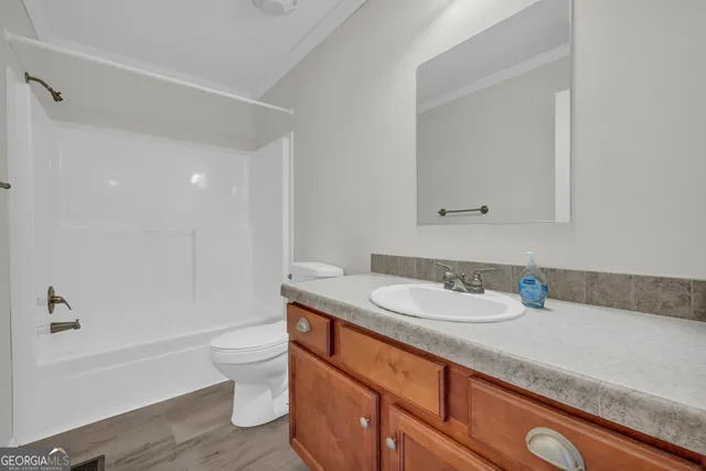 a bathroom with a granite countertop sink a toilet and bathtub
