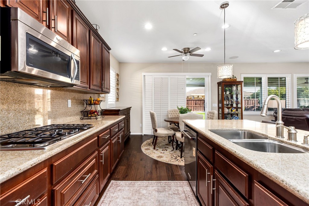 28386 Fox Ridge Cove Menifee, CA 92585 - Photo 17 of 48 a kitchen with stainless steel appliances granite countertop a sink stove and cabinets