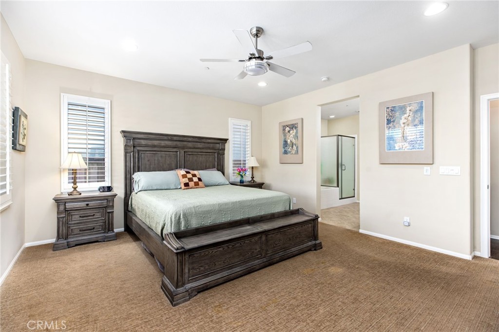 28386 Fox Ridge Cove Menifee, CA 92585 - Photo 21 of 48 a bedroom with a large bed and a chandelier