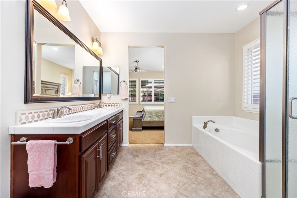 28386 Fox Ridge Cove Menifee, CA 92585 - Photo 23 of 48 a spacious bathroom with a tub sink and mirror