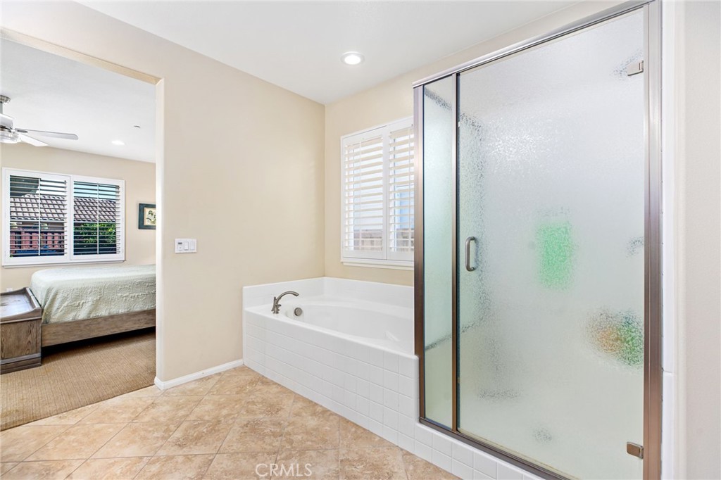 28386 Fox Ridge Cove Menifee, CA 92585 - Photo 24 of 48 a bathroom with a tub shower and window