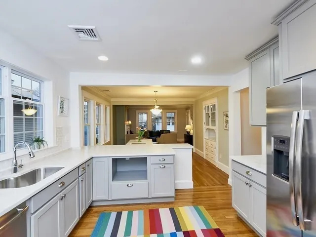 a large kitchen with a large window a sink and stainless steel appliances