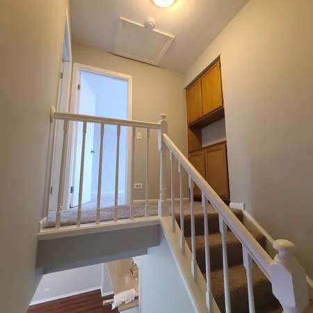 a view of staircase with railing and white walls