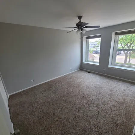 a view of an empty room with a chandelier fan