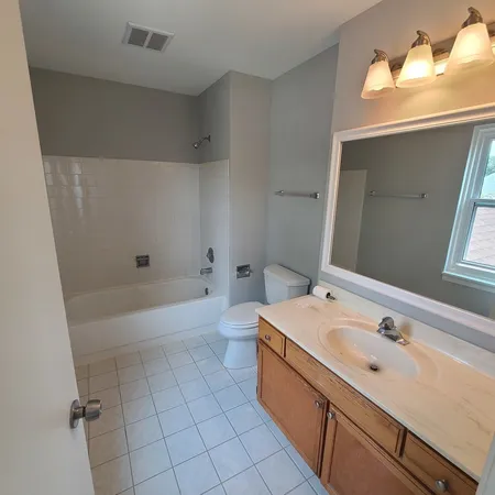 a bathroom with a tub toilet and window