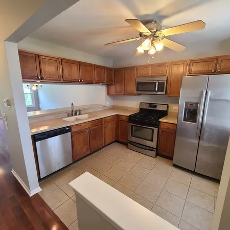 a kitchen with stainless steel appliances granite countertop a sink a stove a microwave a refrigerator a counter top space and cabinets