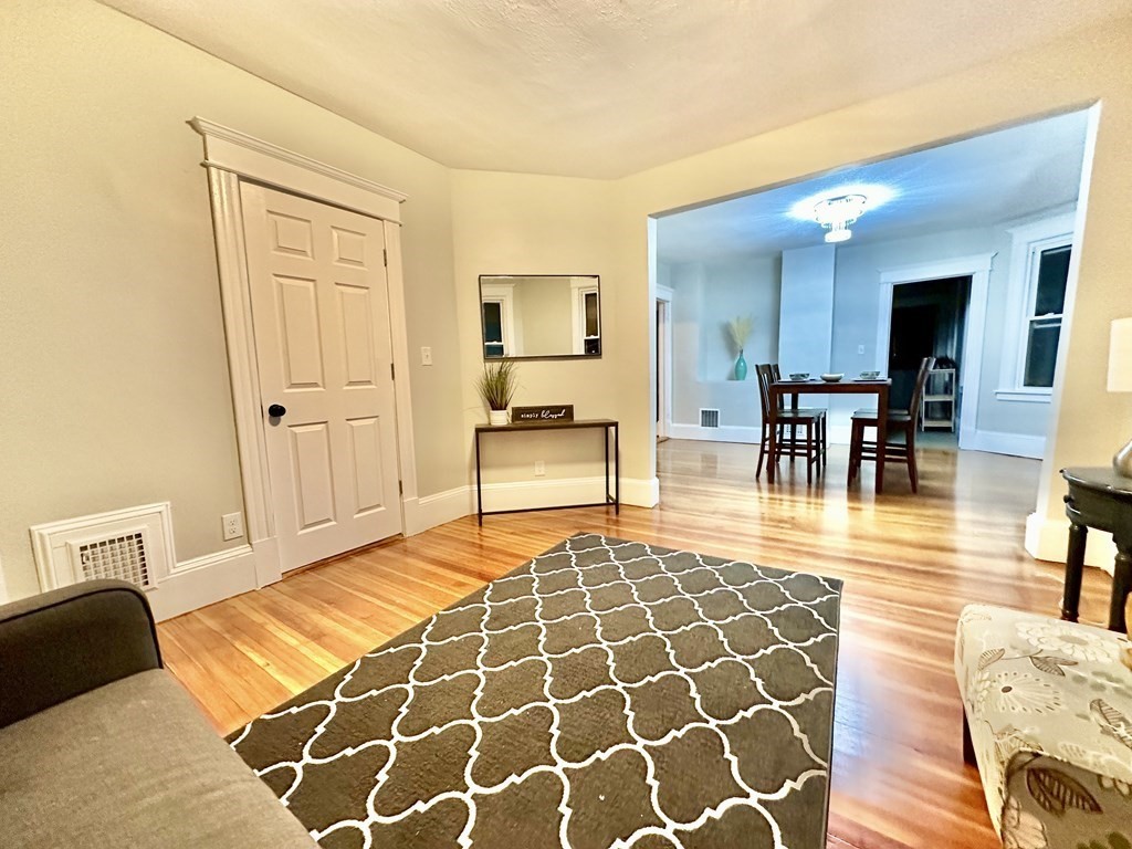 28-30 Kendall Street Springfield, MA 01104 - Photo 3 of 10 a living room with furniture and a dining table with wooden floor