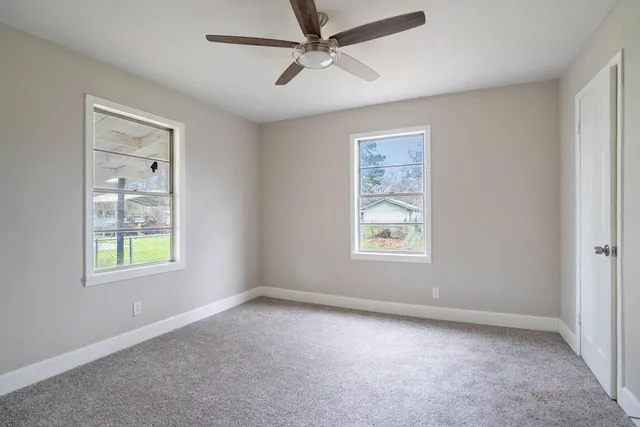 an empty room with windows and closet