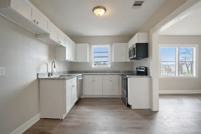 a kitchen with sink a microwave and cabinets