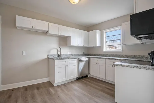 a kitchen with granite countertop cabinets stainless steel appliances and a sink