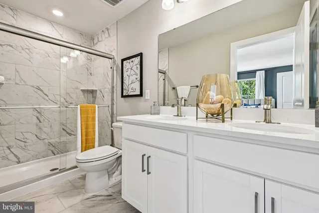 a bathroom with a sink mirror vanity and toilet