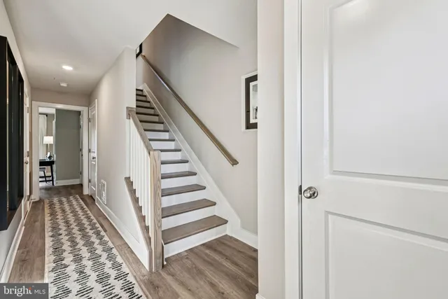 a view of a hallway with wooden floor and entryway