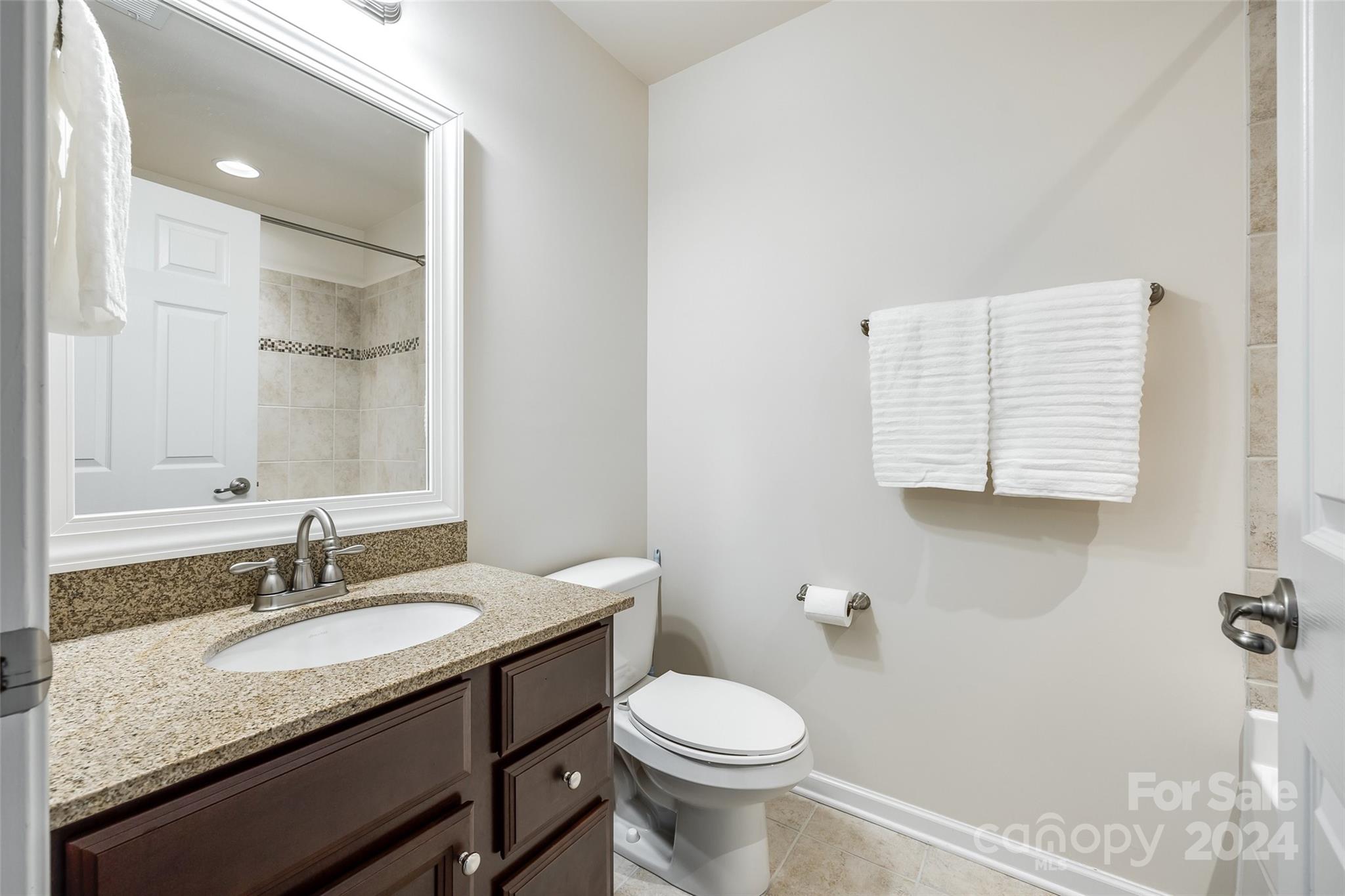 127 Inlet Point Drive Fort Mill, SC 29708 - Photo 13 of 46 a bathroom with a granite countertop sink a mirror and a toilet