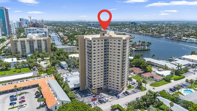 an aerial view of a city with lots of residential buildings ocean and mountain view in back